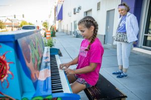 Kenzie Norton, 10, plays a part of the song "Baby Bumblebee" on piano painted by Amber Forrest in front of the Imagine Children’s Museum on Wednesday, Aug. 16, 2023 in Everett, Washington. (Olivia Vanni / The Herald)