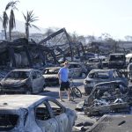 A man walks through wildfire wreckage Aug. 11, in Lahaina, Hawaii. Hawaii emergency management records show no indication that warning sirens sounded before people ran for their lives from wildfires on Maui that wiped out a historic town. (Rick Bowmer / Associated Press)