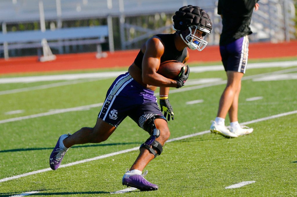 Lake Stevens junior running back Jayshon Limar takes a shovel pass during the Vikings first practice of the year Wednesday, August 16, 2023, in Lake Stevens, Washington. (Ryan Berry / The Herald)