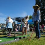 Festival patrons play mini golf for free during Taste Edmonds on Saturday, August 12, 2023, at Frances Anderson Play Field in Edmonds, Washington. (Ryan Berry / The Herald)