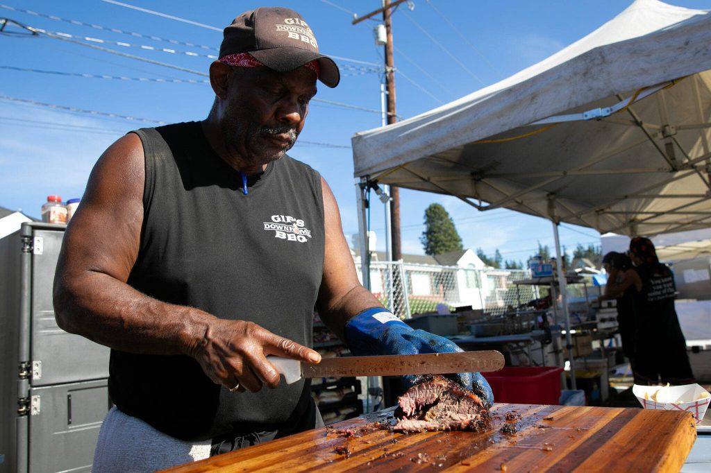 Ron Gipson of Gips Down-Home BBQ slices up some brisket during Taste Edmonds on Saturday, August 12, 2023, at Frances Anderson Play Field in Edmonds, Washington. (Ryan Berry / The Herald)