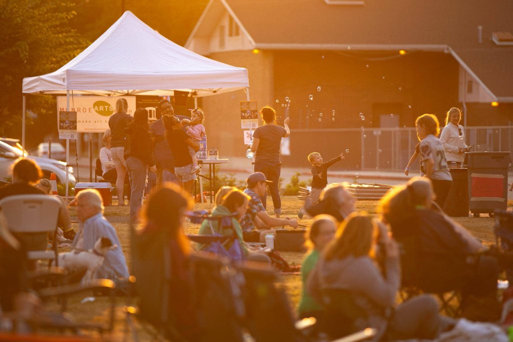 People gather to wait and watch as the sun sets during the Pilchuck Audubon Societys Swift Night Out on Saturday, August 19, 2023, at Frank Wagner Elementary School in Monroe, Washington. (Ryan Berry / The Herald)