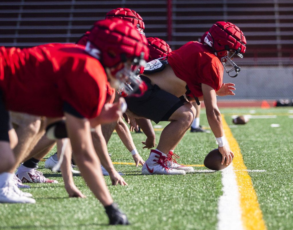A Stanwood player snaps the ball during a drill at practice on Friday, Aug. 18, 2023 in Stanwood, Washington. (Olivia Vanni / The Herald)