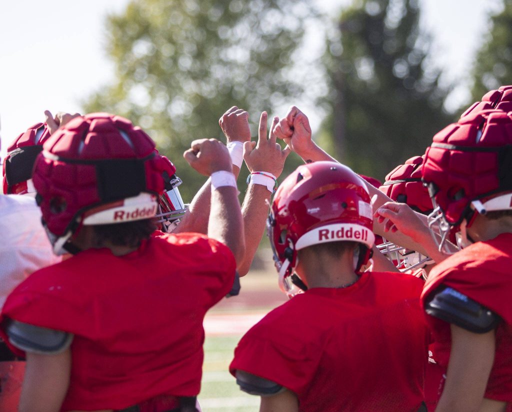 Stanwood players huddle before taking a water break during practice on Friday, Aug. 18, 2023 in Stanwood, Washington. (Olivia Vanni / The Herald)