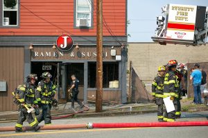 Firefighters work the scene after extinguishing a large fire at J Ramen and Sushi on Saturday, August 19, 2023, on Hewitt Avenue in Everett, Washington. (Ryan Berry / The Herald)