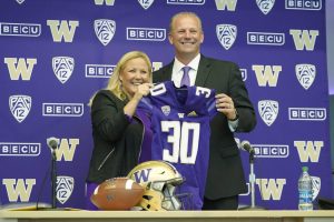Washington athletic director Jen Cohen, left, poses for a photo with Kalen DeBoer, right, Tuesday, Nov. 30, 2021, during a news conference in Seattle, to introduce DeBoer as the new head NCAA college football coach at the University of Washington. DeBoer has spent the past two seasons as head football coach at Fresno State. (AP Photo/Ted S. Warren)
