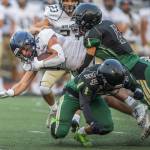 Marysville Getchell players gang up for a tackle during a game against Arlington on Sept. 9, 2022, in Marysville. (Olivia Vanni / The Herald)