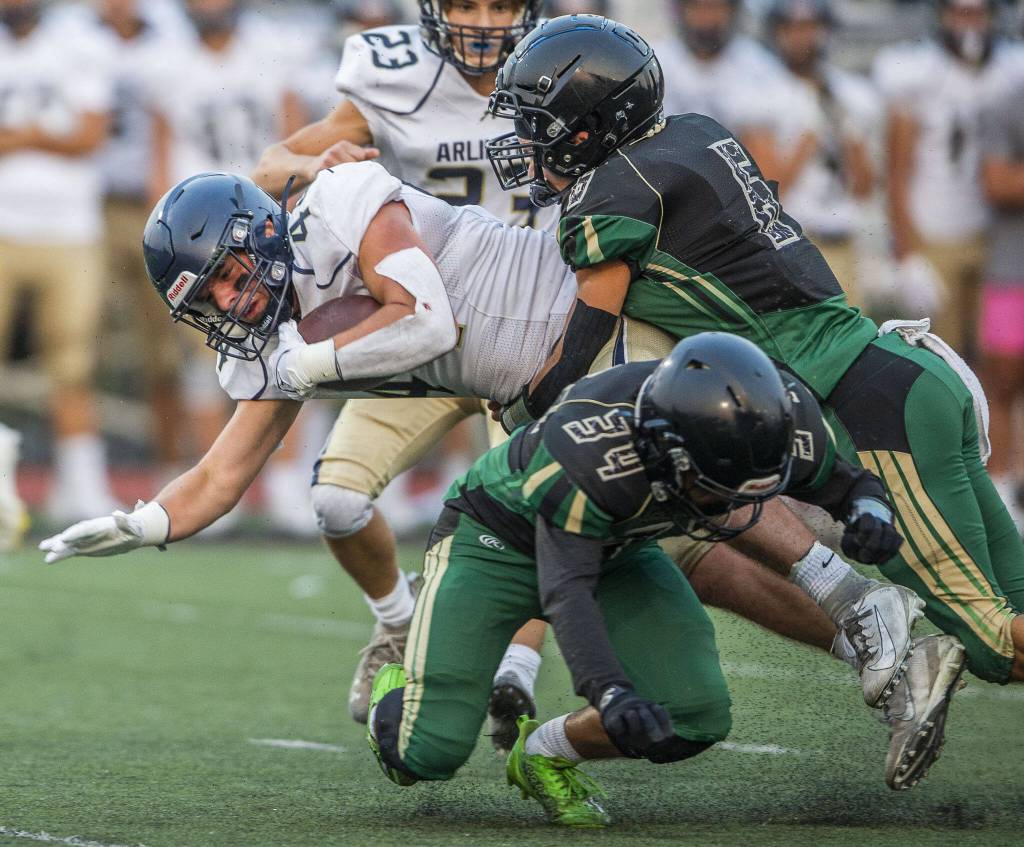 Marysville Getchell players gang up for a tackle during a game against Arlington on Sept. 9, 2022, in Marysville. (Olivia Vanni / The Herald)