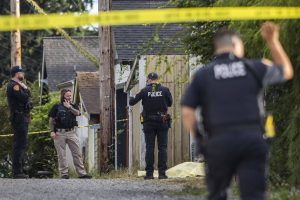 A police officer crosses underneath crime scene tape while walking toward a body in an alleyway on Tuesday, Aug. 22, 2023 in Everett, Washington. (Olivia Vanni / The Herald)