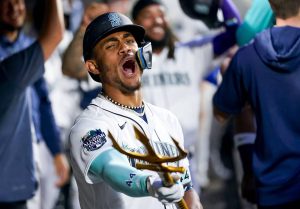 The Mariners Julio Rodriguez points a trident in the dugout as he celebrates a two-run home run to during the fourth inning of a game against the Athletics on Monday in Seattle. (AP Photo/Lindsey Wasson)