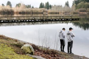Mikael Jacinto (left) and Garrett Oliphant gather samples from Blackmans Lake for testing Saturday morning at Hill Park in Snohomish on February 2, 2019. (Kevin Clark / The Herald)