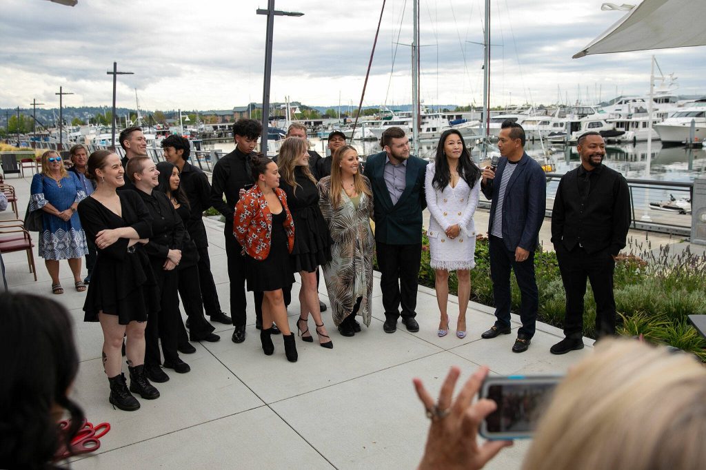 Fisherman Jacks staff join owner Jack Ng, second from right, during a round of speeches during the opening of the Port of Everetts newest restaurant on Wednesday, August 30, 2023, in Everett, Washington. (Ryan Berry / The Herald)