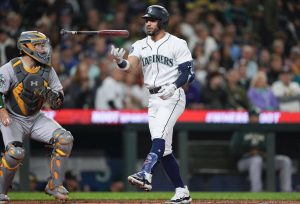 The Mariners Jose Caballero tosses his bat in the air after striking out as Athletics catcher Shea Langeliers looks on during the third inning of a game Tuesday in Seattle. (AP Photo/Lindsey Wasson)