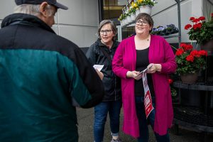 Fred Meyer employees Shawna Wilder, right, and Michelle O’Keefe, left, hand out flyers with information about the grocery merger and chat with a customer on Thursday, April 6, 2023 in Marysville, Washington. (Olivia Vanni / The Herald)