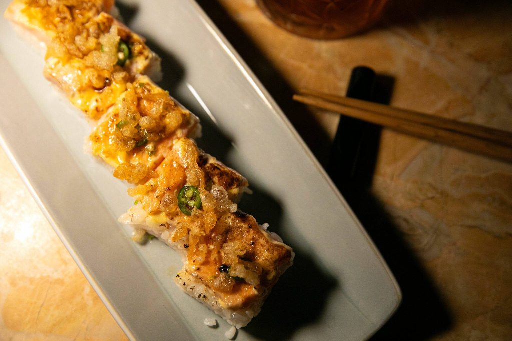 Salmon pressed sushi features serrano peppers and yuzu mayonnaise at 16Eleven on Wednesday, August 23, 2023, in downtown Everett, Washington. (Ryan Berry / The Herald)