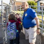 Whittier Elementary para-educator Ian Strum high-fives students as they walk to their first day of school at Whittier Elementary on Wednesday, Sept. 6, 2023 in Everett, Washington. (Olivia Vanni / The Herald)
