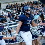 Arlington starting quarterback Leyton Martin runs onto the field during introductions before the season opener against Kamiak on Friday, Sep. 1, 2023, at Arlington High School in Arlington, Washington. (Ryan Berry / The Herald)