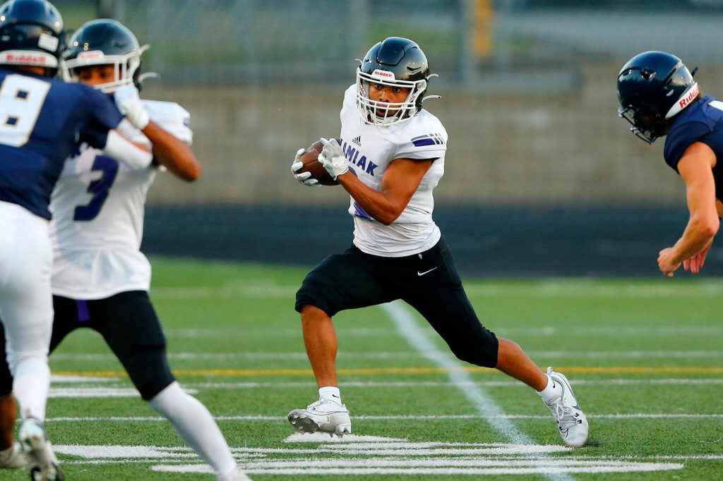 Kamiak junior running back Ezra Davis takes a handoff up the field during the season opener against Arlington on Friday, Sep. 1, 2023, at Arlington High School in Arlington, Washington. (Ryan Berry / The Herald)
