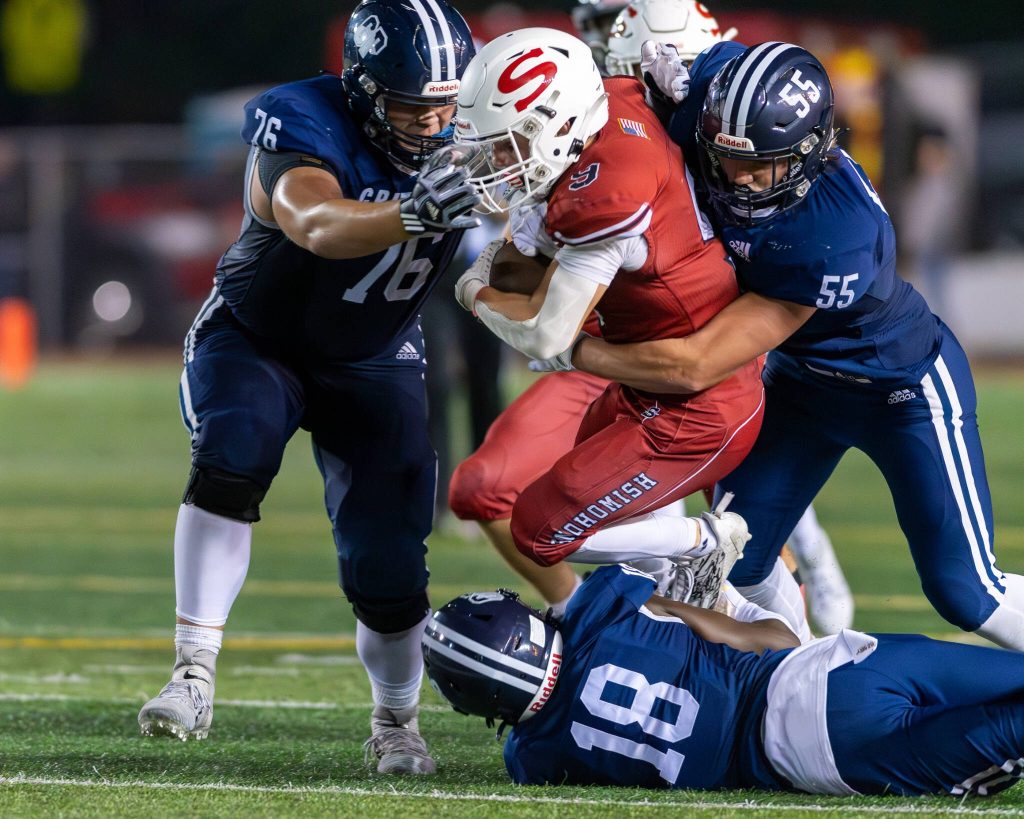 Glacier Peaks Jake Reid (76), Jake McManus (55) and Adam Loum (18) team up to bring down Snohomishs Brody Strandt (9) during a game on Sept. 1, 2023, at Snohomish High School. (John Gardner / Pro Action Image)