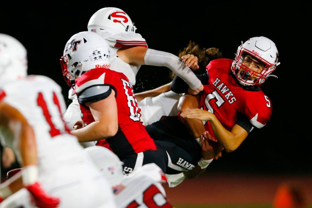 Mountlake Terrace quarterback Arian Motaghedi gets leveled by Snohomish freshman linebacker Ty Tautolo on Friday, Sept. 8, 2023, at Edmonds Stadium in Edmonds, Washington. (Ryan Berry / The Herald)