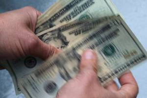 FILE- In this June 15, 2018, file photo, twenty dollar bills are counted in North Andover, Mass.  Record low-interest mortgages are long gone. Credit card rates will likely rise. You'll pay more for an auto loan. The unusually large three-quarter point hike, Wednesday, June 15, 2022 in the Fed's benchmark short-term rate is going to have a lot of impacts on Americans' finances. The hope is that by making borrowing more expensive, the Fed will succeed in cooling demand for homes, cars and other goods and services and slow inflation (AP Photo/Elise Amendola, File)