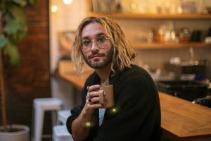 Local musician Alex Johnston, whose newest album "Daylight Fooldream" pairs with short film he made with help from his partner Mikaela Henderson, sits with his morning coffee on Friday, Sept. 15, 2023, at Narrative Coffee in Everett, Washington. (Ryan Berry / The Herald)