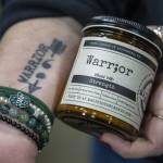 Owner and CEO Lacie Carroll holds a Warr;or candle at the Malicious Women Candle Co workspace in Snohomish, Washington on Wednesday, Feb. 15, 2023. The business is women run and owned. (Annie Barker / The Herald)