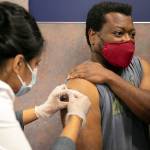 Everett resident Shon Grimes receives a flu shot from pharmacist Nisha Mathew at Bartell Drugs on Broadway on Saturday, Oct. 1, 2022, in Everett, Washington. (Ryan Berry / The Herald)