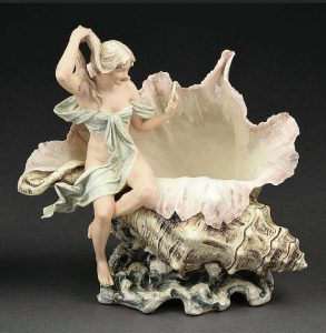 Some collectibles are found in nature; some imitate them. If it werent for the attached figure, this Royal Dux porcelain vase might pass for a real conch shell.