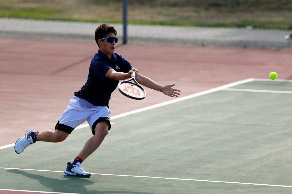 Arlington’s Robbie Balderas chases down a ball and sends it back over the net during a match against Everett High on Monday, Sept. 18, 2023, at his school’s home court in Arlington, Washington. (Ryan Berry / The Herald)