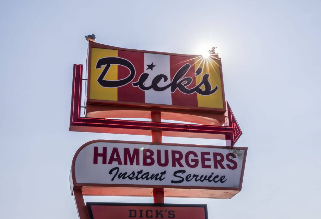 Two seagulls sit on top of the Dicks sign on Friday, Sept. 22, 2023 in Edmonds, Washington. (Olivia Vanni / The Herald)