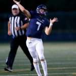 Arlington quarterback Leyton Martin connects on a rollout pass against Ferndale on Friday, Sept. 22, 2023, at Arlington High School in Arlington, Washington. (Ryan Berry / The Herald)