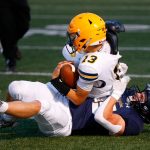 Arlingtons Bookie Cramer takes down a scrambling Bishop Ootsey during a game against Ferndale on Friday, Sept. 22, 2023, at Arlington High School in Arlington, Washington. (Ryan Berry / The Herald)