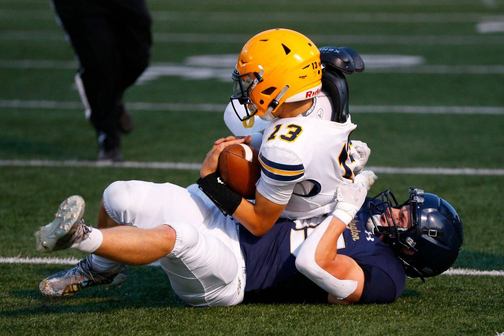 Arlingtons Bookie Cramer takes down a scrambling Bishop Ootsey during a game against Ferndale on Friday, Sept. 22, 2023, at Arlington High School in Arlington, Washington. (Ryan Berry / The Herald)