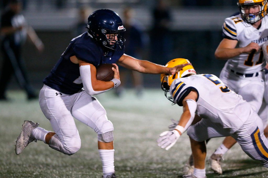 Arlingtons Caleb Reed tries to evade a defender against Ferndale on Friday, Sept. 22, 2023, at Arlington High School in Arlington, Washington. (Ryan Berry / The Herald)