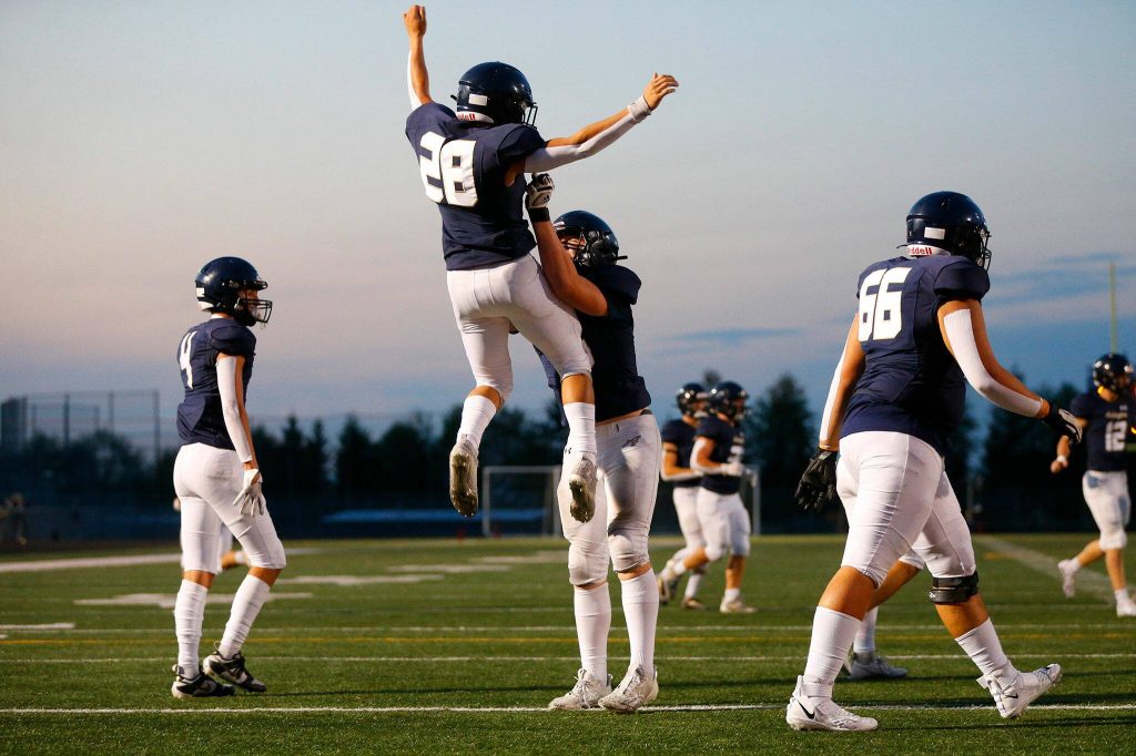 Arlingtons Caleb Reed is thrown into the air by lineman Dylan Scott after scoring a touchdown against Ferndale on Friday, Sept. 22, 2023, at Arlington High School in Arlington, Washington. (Ryan Berry / The Herald)