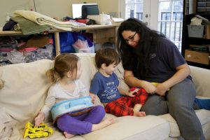 Patricia Gambis, right, talks with her 4-year-old twin children, Emma, left, and Etienne in their home, Thursday, Jan. 24, 2019, in Maplewood, N.J. Gambis' husband, an FBI agent, has been working without pay during the partial United States government shutdown, which has forced the couple to take financial decisions including laying off their babysitter. (AP Photo/Julio Cortez)