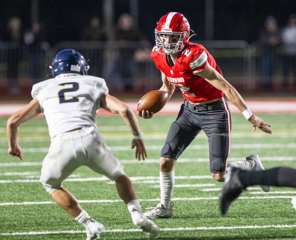 Stanwoods Luke Brennan scrambles with the ball during the game against Arlington on Friday, Sept. 29, 2023 in Stanwood, Washington. (Olivia Vanni / The Herald)