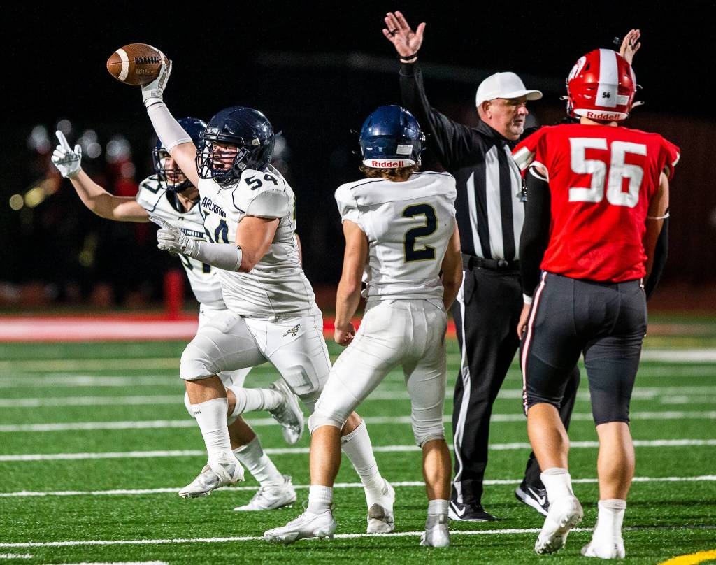 Arlingtons Nolan Welch-Downing runs with the football and cheers after forcing a turnover during the game against Stanwood on Friday, Sept. 29, 2023 in Stanwood, Washington. (Olivia Vanni / The Herald)