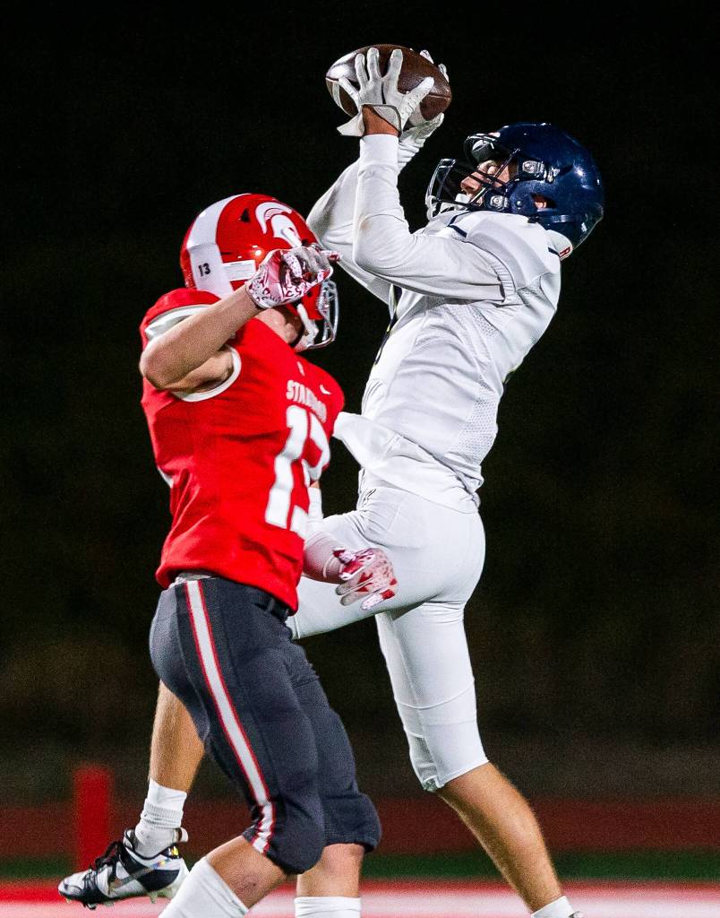 Arlingtons Jake Willis leaps above Stanwoods Cole Williams to make a catch during the game on Friday, Sept. 29, 2023 in Stanwood, Washington. (Olivia Vanni / The Herald)