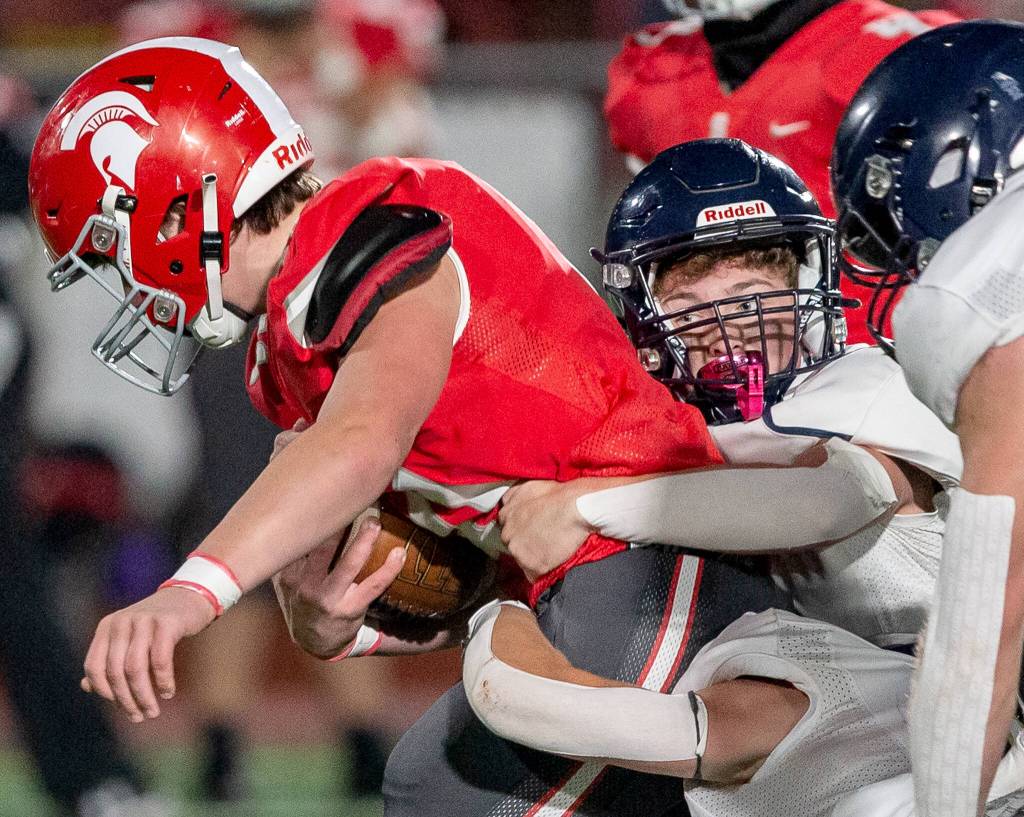 Multiple Alrington players tackle a Stanwood player during the game on Friday, Sept. 29, 2023 in Stanwood, Washington. (Olivia Vanni / The Herald)