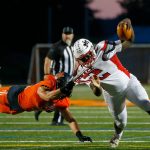Mountlake Terraces Zaveon Jones is pulled to the ground by a diving Nicholas Mouser of Monroe on Friday, Sept. 29, 2023, at Monroe High School in Monroe, Washington. (Ryan Berry / The Herald)