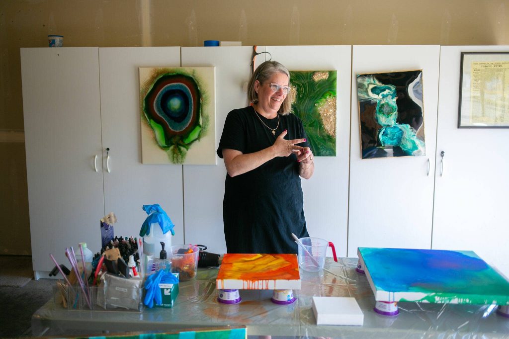 Downes prepares to work on a few canvases in her studio, which is in the garage of her Stanwood home. (Ryan Berry / The Herald)