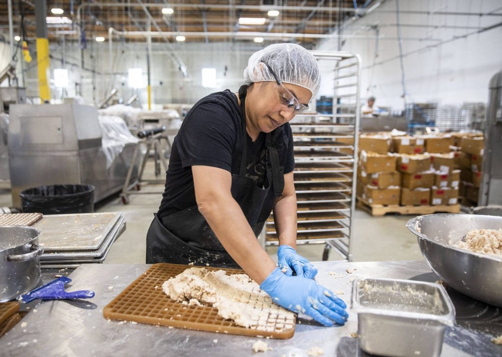 Magaly Jarquin makes small cheese cubes on Thursday, Sept. 21, 2023 in Arlington, Washington. (Olivia Vanni / The Herald)
