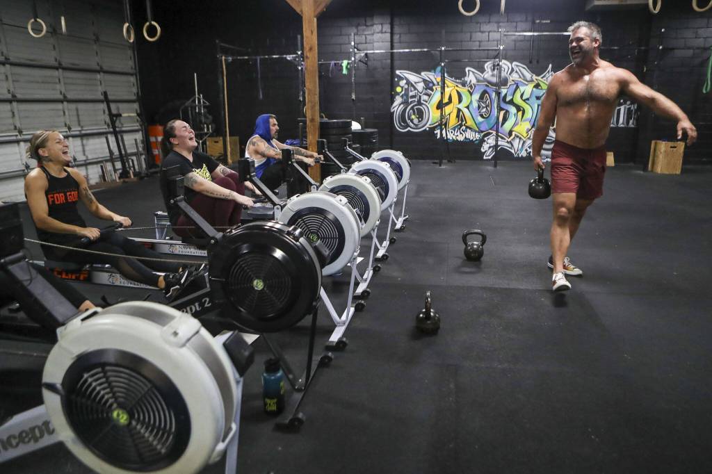 Adam Olsen, right, smiles while completing training exercises during a class lead by Harrison Wolff at Remedy Athletics in Marysville, Washington on Wednesday, Oct. 11, 2023. (Annie Barker / The Herald)
