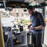 Jordan Hansen takes out cash to pay for a bus ticket on the 512 to Northgate on Wednesday, Oct. 4, 2023 in Everett, Washington. (Olivia Vanni / The Herald)