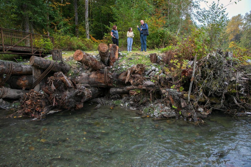 Keith Binkley, natural resources manager at Snohomish County PUD, right, stands along the edge of the Sultan River while discussing habitat restoration efforts at Osprey Park on Friday, Oct. 6, 2023, in Sultan, Washington. (Ryan Berry / The Herald)