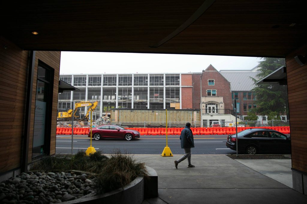 A man walks down broadway across from the Compass Health Broadway Campus Redevelopment project Thursday, Oct. 12, 2023, in Everett, Washington. (Ryan Berry / The Herald)
