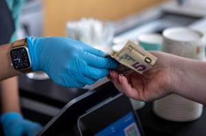 Cash is used for a purchase at Molly Moon's Ice Cream in Edmonds, Washington on Wednesday, Aug. 30, 2023. (Annie Barker / The Herald)