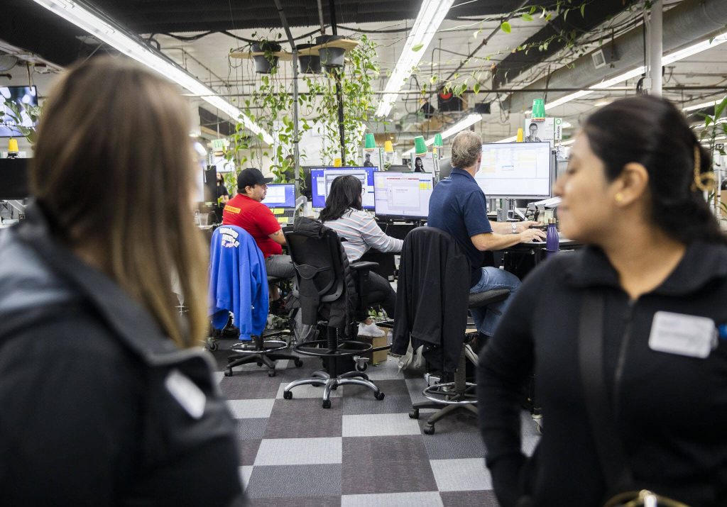 Kaas Tailored employees work while people tour their facility on Tuesday, Oct. 10, 2023 in Mukilteo, Washington. (Olivia Vanni / The Herald)